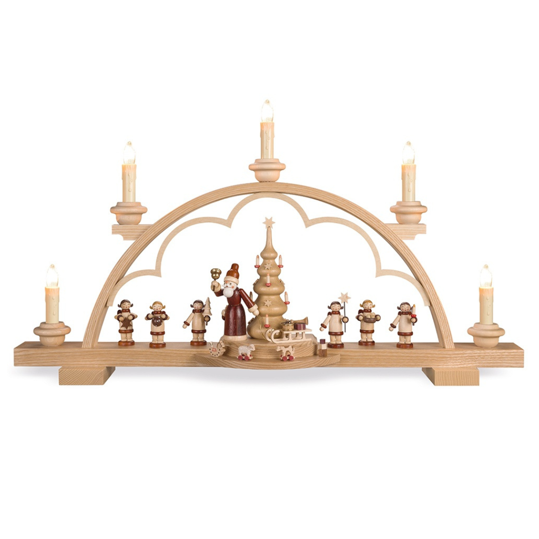 A wooden electric candle arch decoration featuring figures of Santa, angels, and a sled, designed for use during the Christmas season by Mueller GmbH