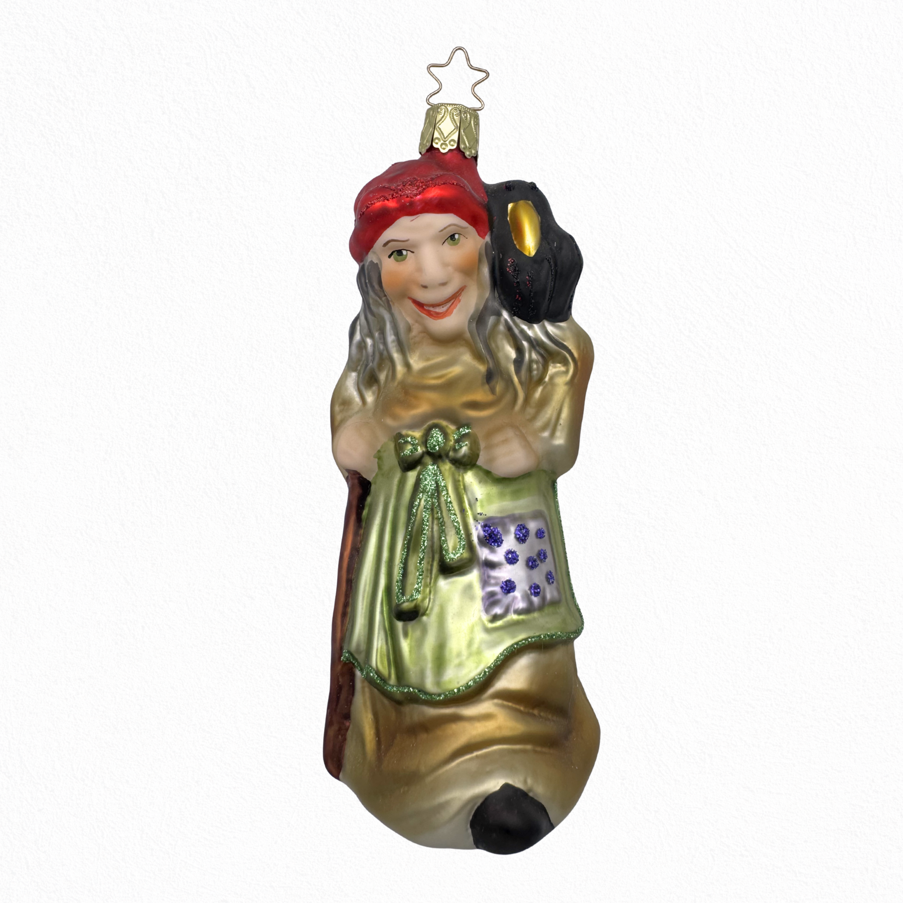 A hand-painted glass ornament featuring a character resembling the Wicked Witch, with a realistic face, crow on her shoulder with gold, red, purple and green colors, and a star at the top for hanging.