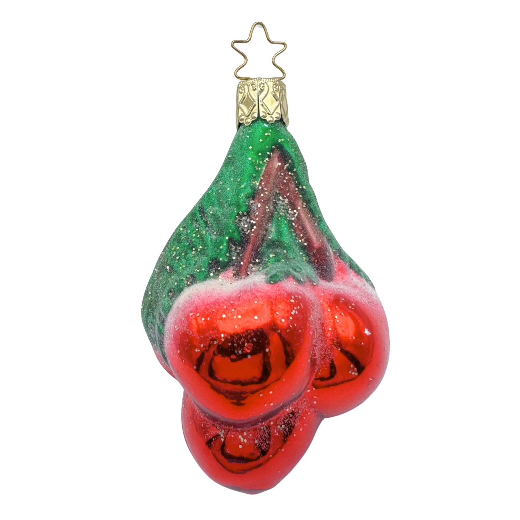 Decorative glass ornament shaped like a cluster of red cherries with stems and green leaves on a white background