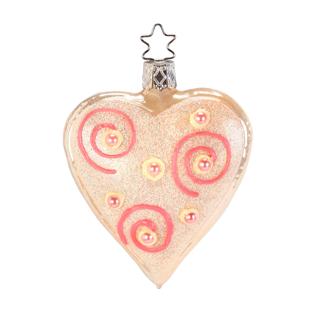Heart-shaped ornament with pink swirls and a star on top against a white background