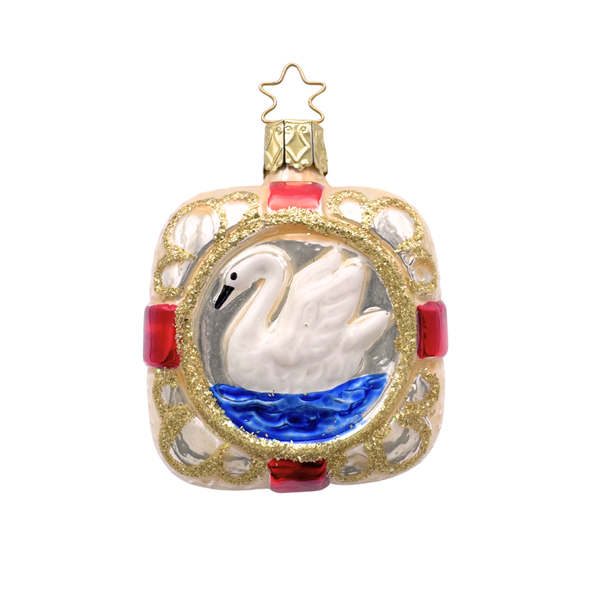 Decorative glass Christmas ornament of a swan swimming in the center of a square accented with red stripes and gold glitter with a gold star top for hanging by Inge Glas of Germany.
