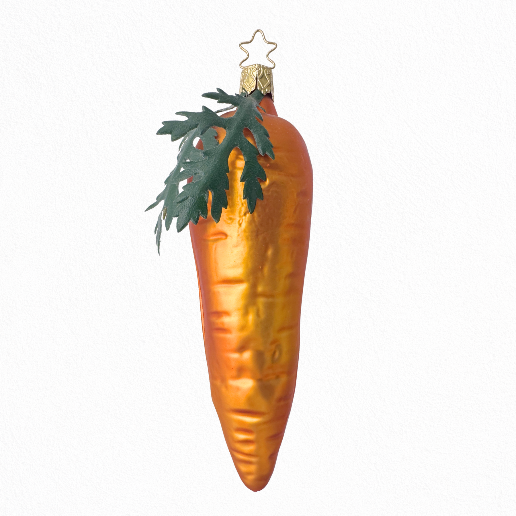 A large orange glass carrot ornament with leaf detailing, intended for seasonal decoration.