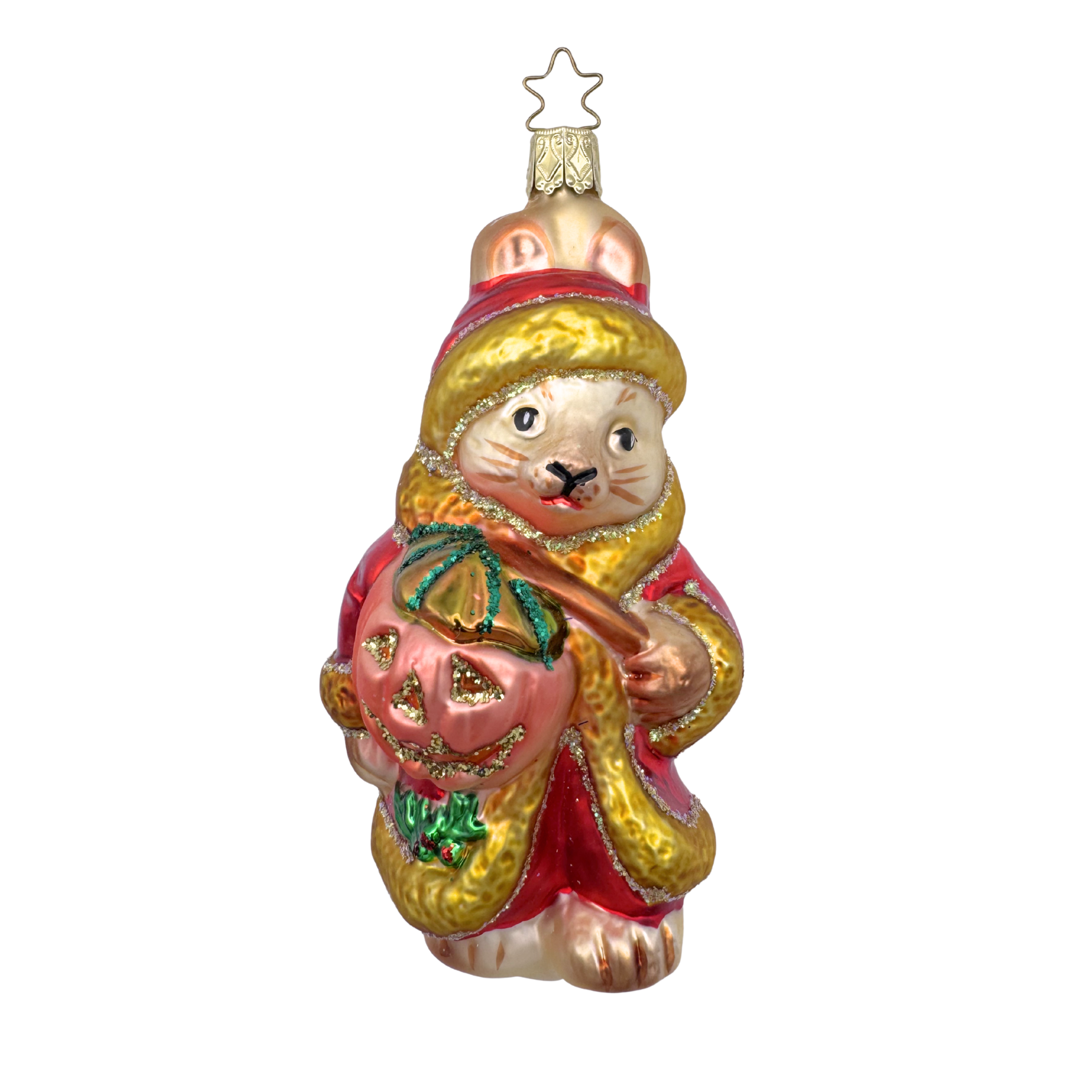 A glass ornament featuring a stylized bunny wearing a red Santa hat and coat, carrying a jack-o-lantern, and adorned with gold trimmings.