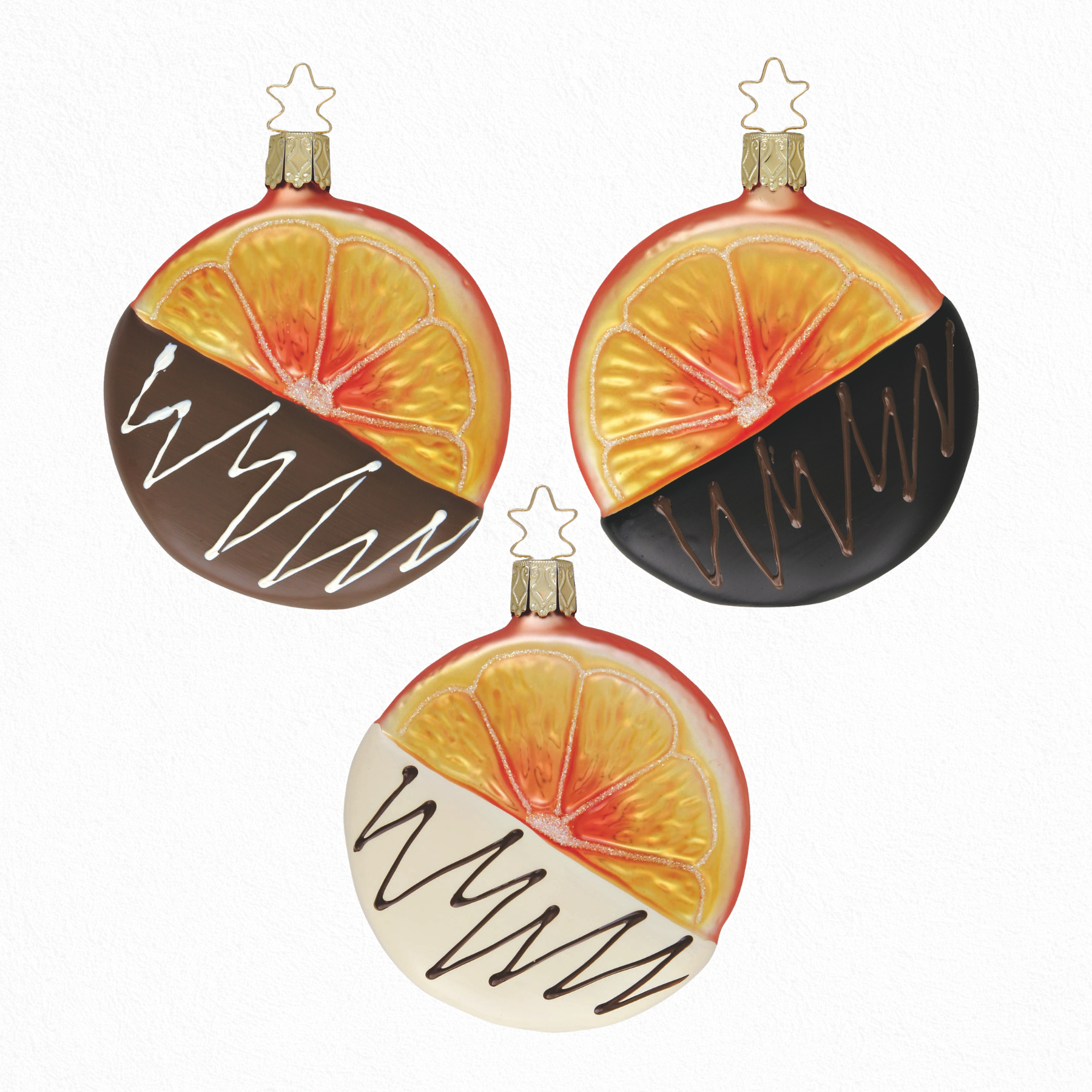 Three round Christmas ornaments with orange slice design dipped in chocolate with a gold star top for hanging on a white background
