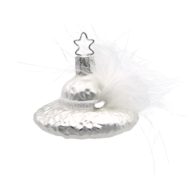 Decorative glass Christmas ornament of a woman's white hat adorned with a feather and a Swarovski marquis shaped jewel with a silver star top for hanging by Inge Glas of Germany.