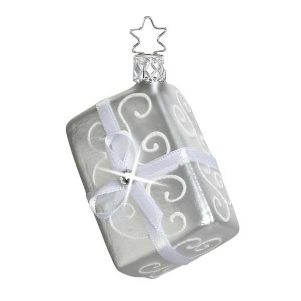 Silver gift ornament with a star topper for hanging and a swirl design and a matte finish with white bow and gem accent.