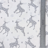 Close up pattern of stags and stars in a dark silvery gray on a light gray background with a ruler to show scale.