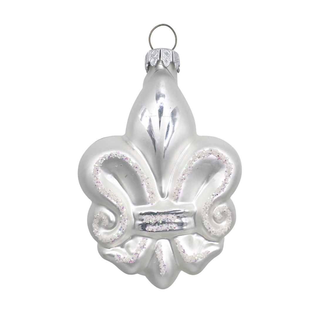 Decorative glass ornament with a silver and white fleur-de-lis design on a white background