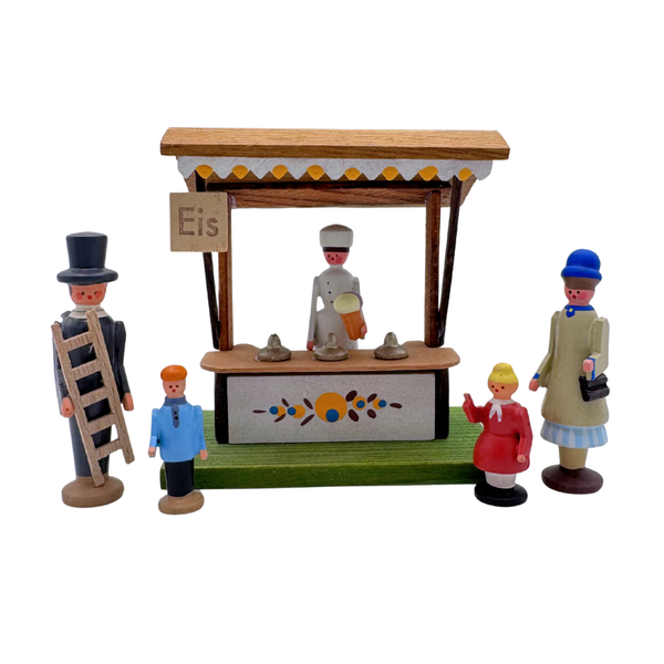 Set of miniature five wood figures around a ice cream stand with 'Eis' sign on a white background