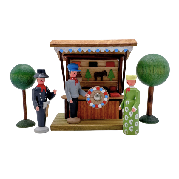 Wooden colorful miniature figures set with a games booth, people, and trees on a white background