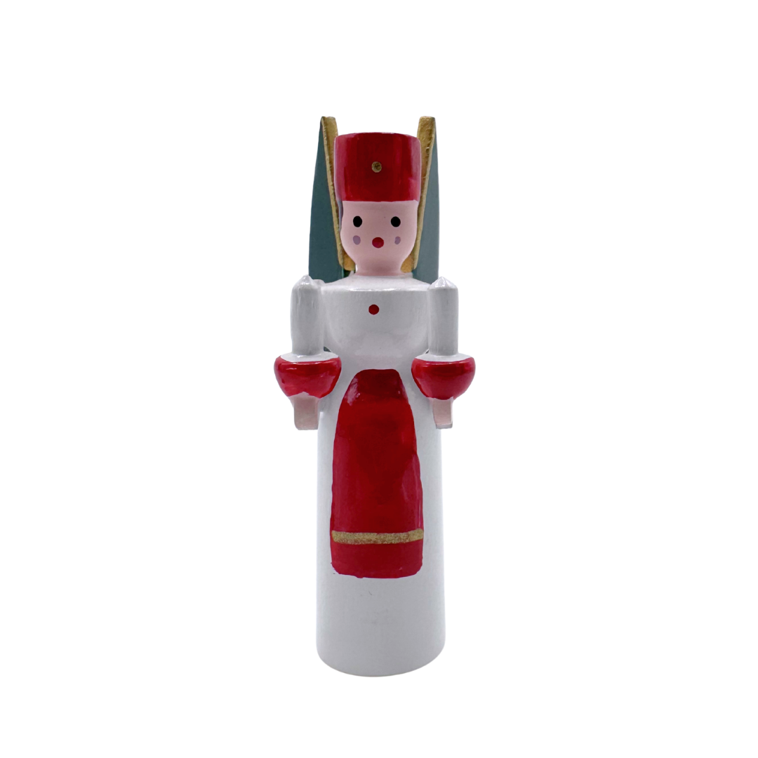 Wooden miniature figurine  of an angel with red and white attire, holding two wood candles on a white background