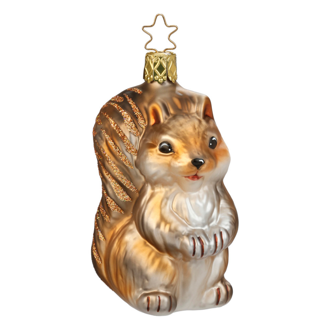 A glassblown and hand-painted squirrel ornament with a star on top, primarily in brown and white colors.