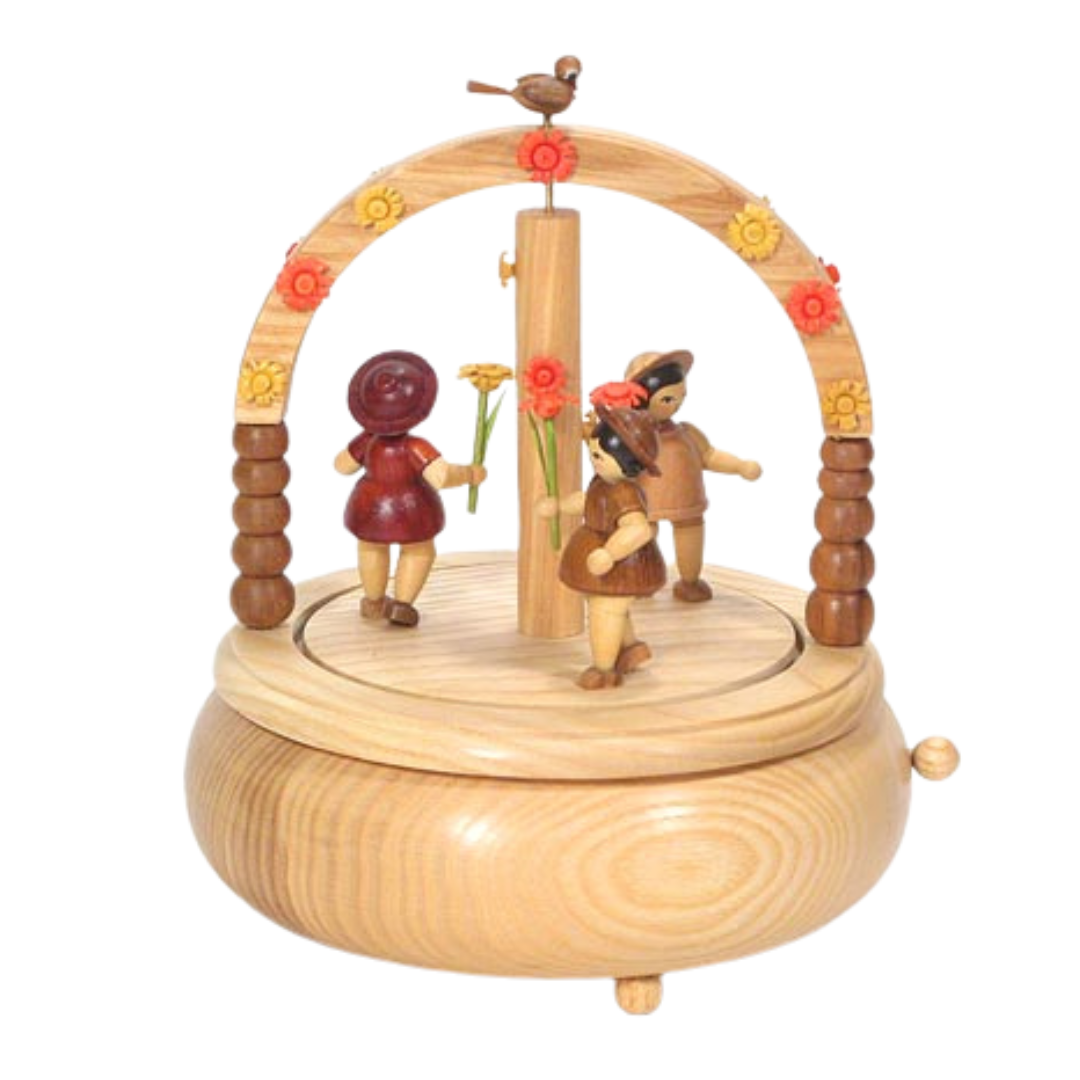 Round natural wood music box with a flower arch and children playing underneath.